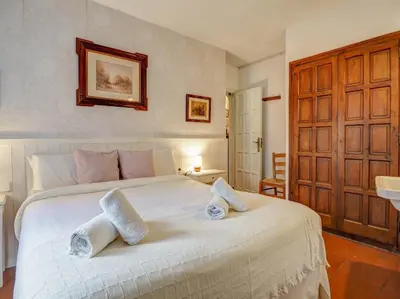 a bedroom with a large white bed with towels on it at Red Velvet Apartment by Hello Homes Sitges in Sitges