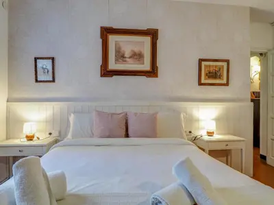a bedroom with a large white bed with two tables at Red Velvet Apartment by Hello Homes Sitges in Sitges