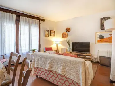 a living room with a bed and a television at Red Velvet Apartment by Hello Homes Sitges in Sitges