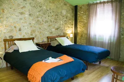 two beds in a room with a wall at Ca l'Helena in Castellet