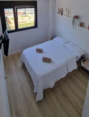 a bedroom with a white bed with two towels on it at Confortable habitación doble - 1 in Sant Adria de Besos