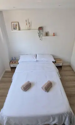 a white room with two beds and a window at Confortable habitación doble - 1 in Sant Adria de Besos