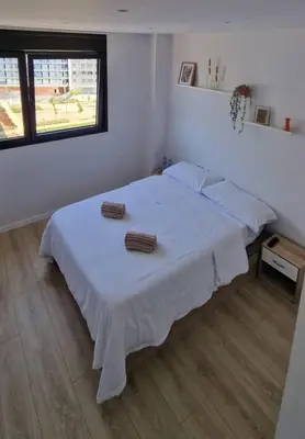 two bottles of water and a remote control on a nightstand at Confortable habitación doble - 1 in Sant Adria de Besos