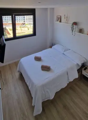 two beds in a bedroom with white walls at Confortable habitación doble - 1 in Sant Adria de Besos