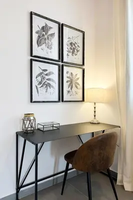 a desk with a chair and three framed pictures on the wall at Bebarceloner Poble Nou Apartments - 1 bedroom in Barcelona