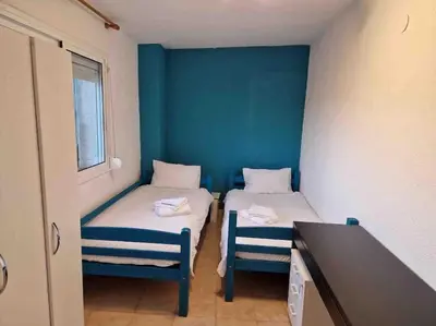 a small room with two beds and a table at Le Petit Paradis Olivella in Olivella