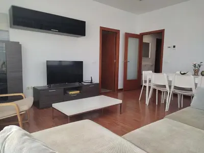a living room with a couch and a tv and a table at Ap4Us B1 - Apartment for us - Sightseeing & Beach near to Barcelona in Badalona