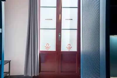 a red door in a room with a curtain at Malacuna Barcelona in Barcelona
