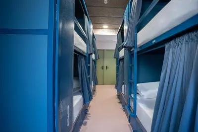 a corridor of a room with blue bunk beds at Malacuna Barcelona in Barcelona