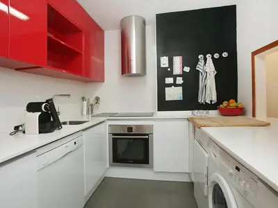 a kitchen with white counters and red cabinets at Apartment Vila Olimpica Pamplona by Interhome in Barcelona