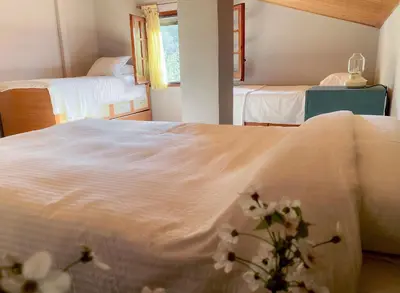 a bedroom with two beds with white sheets and flowers at Casa Magnolia in Dosríus