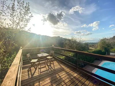 a wooden deck with a table and chairs on it at Casa Magnolia in Dosríus