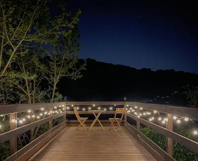 a wooden boardwalk with lights on it at night at Casa Magnolia in Dosríus