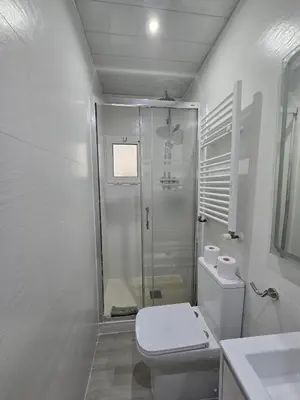 a white bathroom with a toilet and a shower at Beach Apartment Barca 6 in Sant Adria de Besos