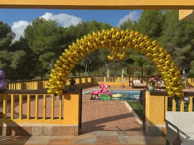 a gold arch in front of a pool at Villa Golf Sitges in Vilanova i la Geltrú