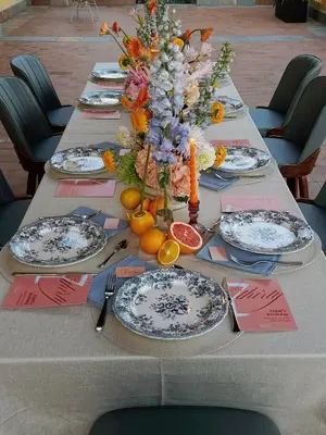a long table with plates of food and flowers on it at Villa Golf Sitges in Vilanova i la Geltrú