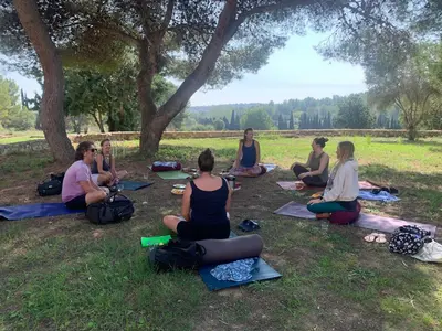 a group of people sitting in the grass under a tree at Villa Golf Sitges in Vilanova i la Geltrú