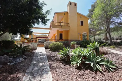 a house in the middle of a garden at Villa Golf Sitges in Vilanova i la Geltrú