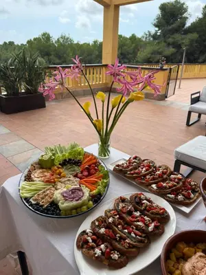 a table with several plates of food on it at Villa Golf Sitges in Vilanova i la Geltrú