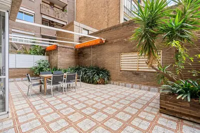 a patio with a table and chairs and a building at Sunny Terrace Retreat AC 3BR2BA in Barcelona