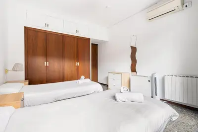 a room with three beds with white sheets at Sunny Terrace Retreat AC 3BR2BA in Barcelona