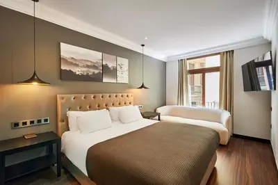 a hotel room with two beds and a window at Hotel Cortes Rambla in Barcelona