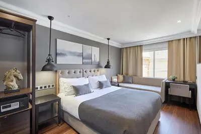 a bedroom with a large bed and a couch at Hotel Cortes Rambla in Barcelona