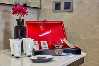 a red box on a table with a flower in it at Hotel Cortes Rambla in Barcelona