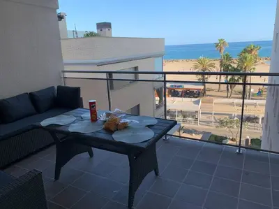 a patio with a couch and a table on a balcony at Cunit, front line with sea view in Cunit