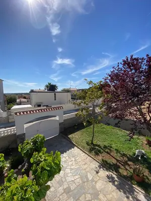 a view of a backyard with a fence and trees at Villa Felicidad in Vilanova i la Geltrú