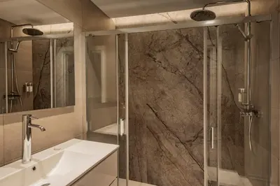 a bathroom with a shower with a sink and a mirror at Europa Apartments in Hospitalet de Llobregat