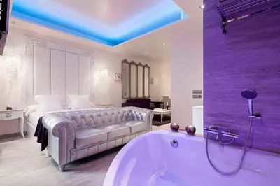 a large bathroom with a tub and a bed at Romantic Barcelona Apartment in Barcelona