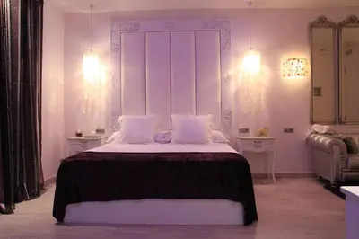 a white bedroom with a large bed with white pillows at Romantic Barcelona Apartment in Barcelona