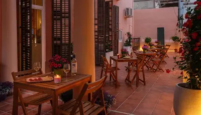 a patio with tables and chairs with wine glasses and candles at Antonios Hostal in Sitges