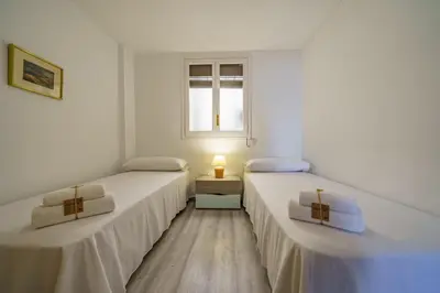 two twin beds in a room with a window at HomeHolidaysRentals Aquilone - Costa Barcelona in Pineda de Mar