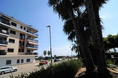 a street view of a building and a palm tree at HomeHolidaysRentals Fortuny - Costa Barcelona in Pineda de Mar