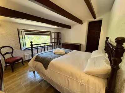 a bedroom with a large bed and a window at Cal Poldo in Marganell