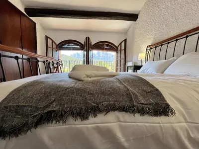 a bedroom with a large bed with a large window at Cal Poldo in Marganell