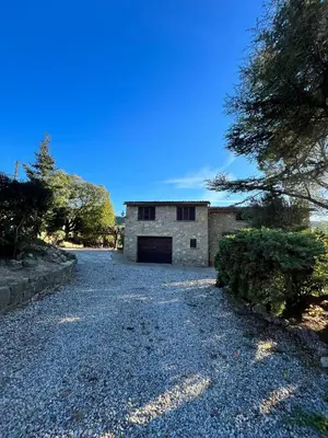 a building with a garage on a gravel driveway at Cal Poldo in Marganell