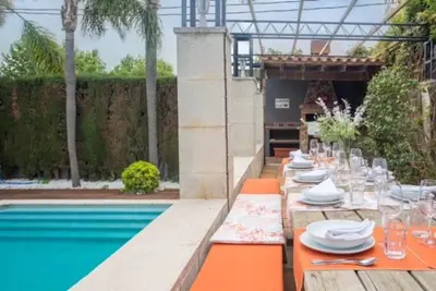 a table with plates and glasses on it next to a pool at Luxury Villa Cela in Masnou