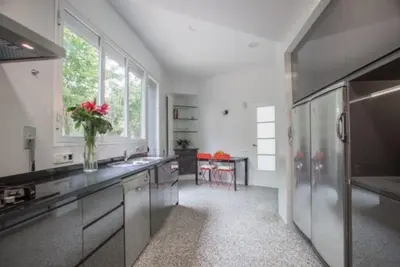 a large kitchen with a vase of flowers on the counter at Luxury Villa Cela in Masnou