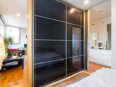 a large glass closet in a room with a bed at Loft Bouquet Alella mar y montaña 25 min a BCN in Alella