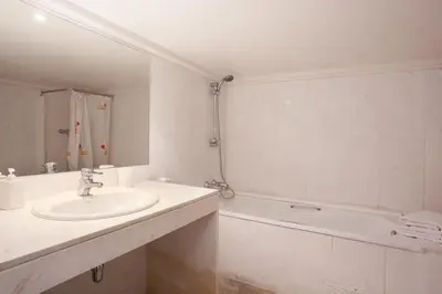a white bathroom with a sink and a bath tub at LetsGo Paseo de Gracia in Barcelona