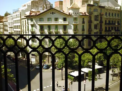 a view of a city street through a fence at Gaudi Apartment 9 in Barcelona