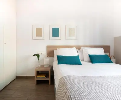 a dining room with a table and chairs and a couch at Feelathome Plaza Apartments in Barcelona