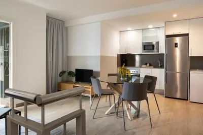 a white dining room table with chairs and a tv at Feelathome Plaza Apartments in Barcelona