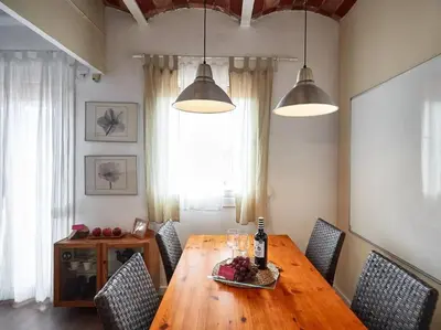 a dining room table with chairs and a bottle of wine at Bed&BCN Arquimedes Barcelona in Barcelona