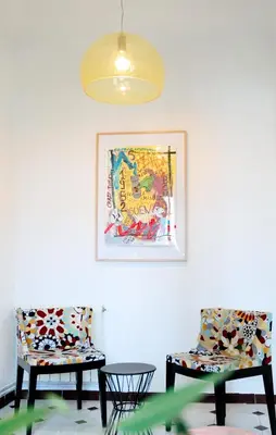two chairs and a table in a room with a picture at Alma Azul Consell de Cent in Barcelona