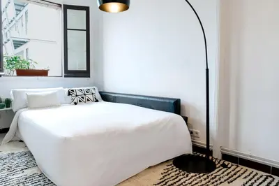 a bedroom with a white bed and a window at Alma Azul Consell de Cent in Barcelona