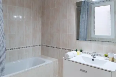 a bathroom with a tub and a sink and a mirror at Alma Azul Consell de Cent in Barcelona